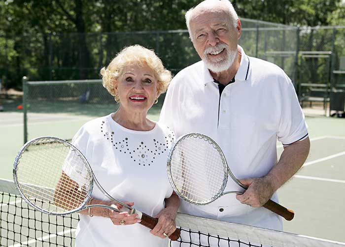 Older couple getting ready to play tennis