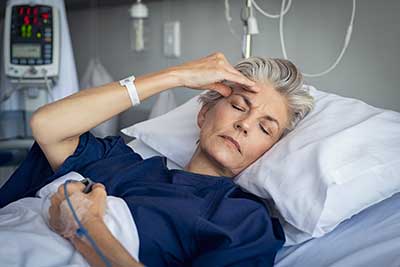 Woman suffering headache in hospital with drip